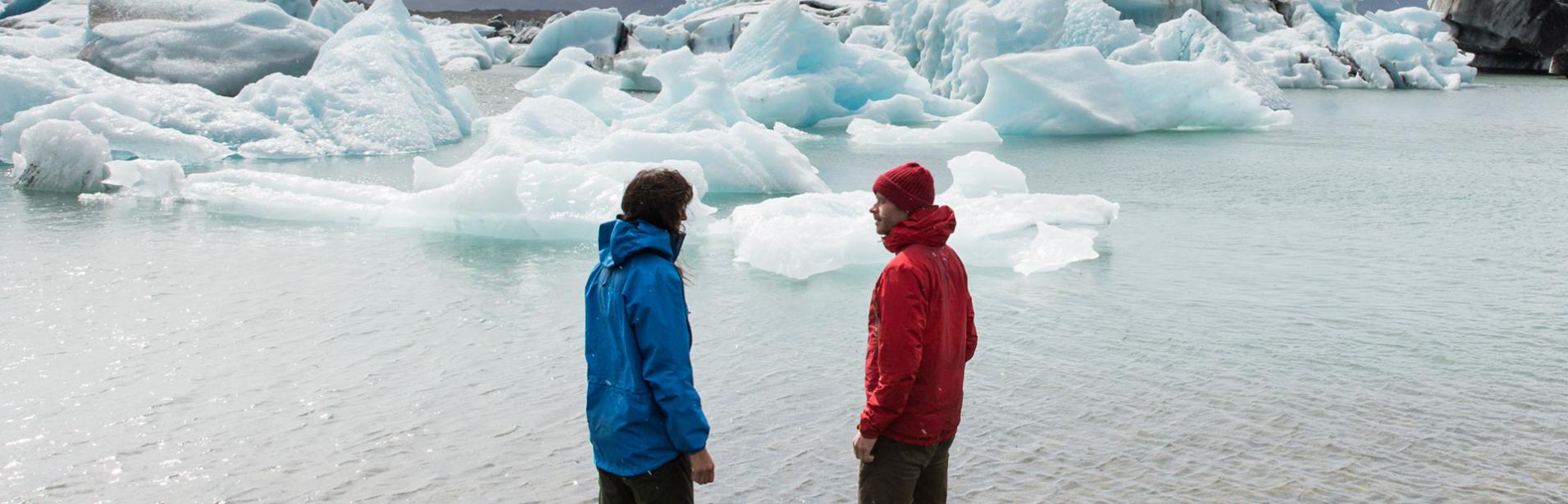 Ett par beskådar glaciär lagunen på Island.
