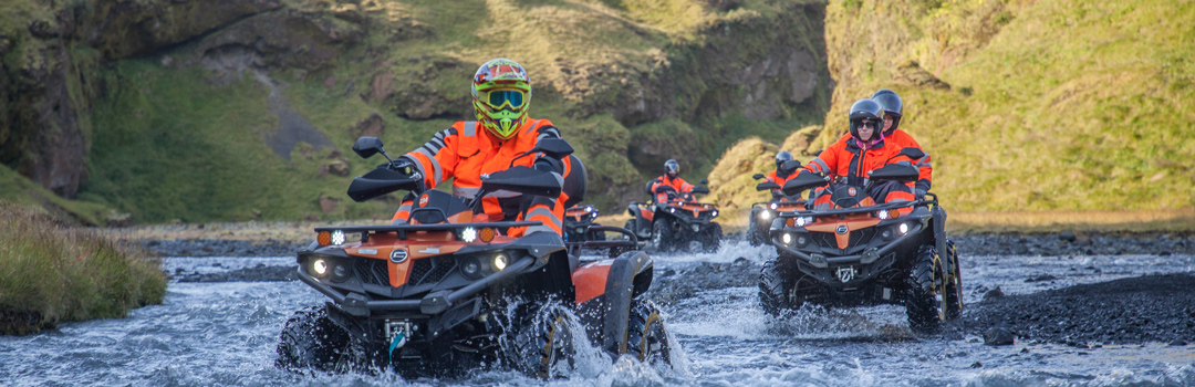 ATV-förare korsar en älv i det isländska landskapet.