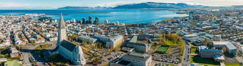 Flygfoto över Reykjavik med Hallgrímskirkja och havet i bakgrunden.