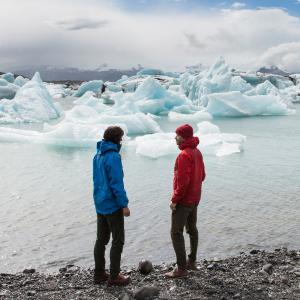 Ett par beskådar glaciär lagunen på Island.